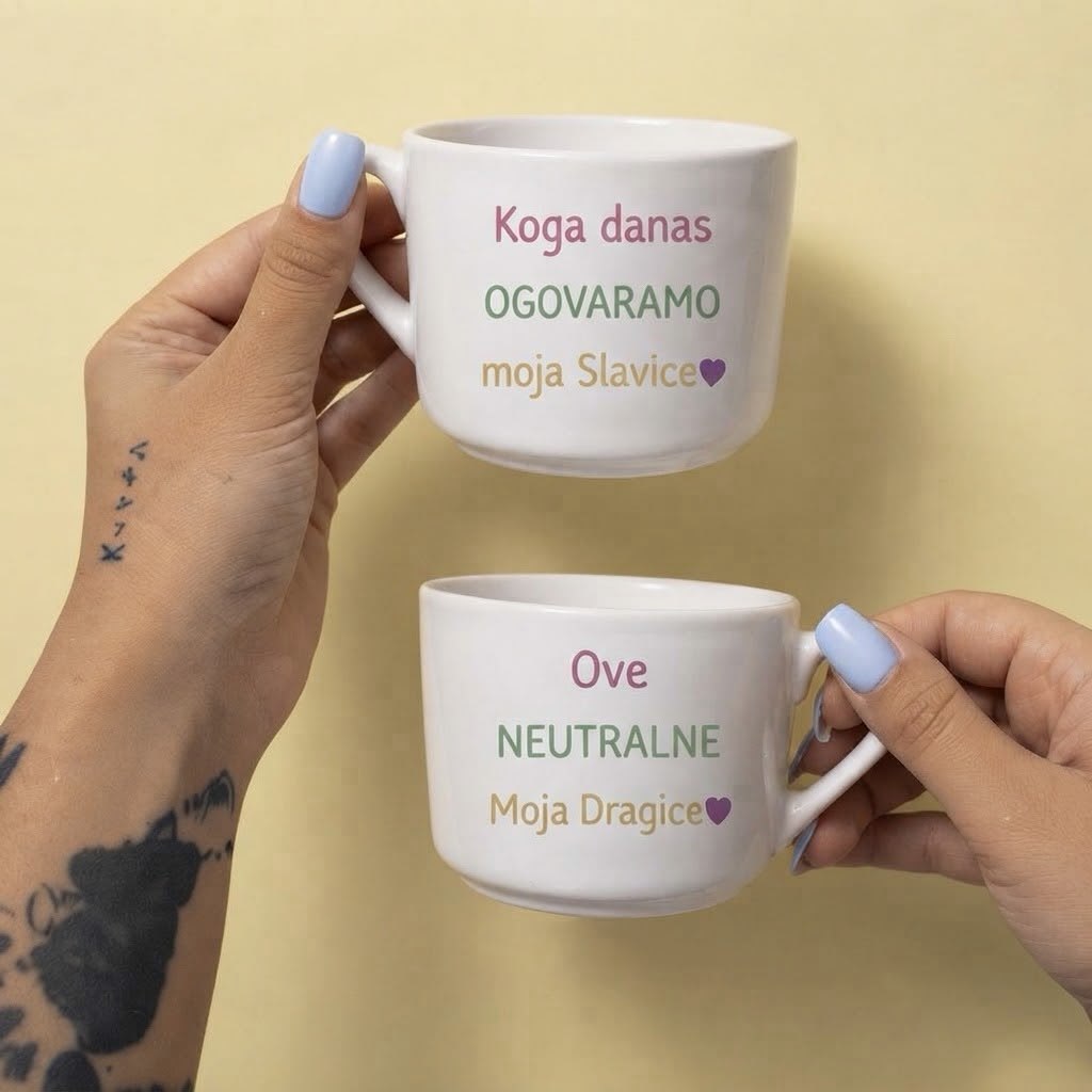 Dve bele šolje u ruci, natpisi Koga danas ogovaramo moja Slavice i Ove neutralne moja Dragice